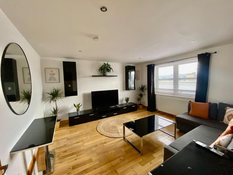 a living room with a couch and a tv at City centre apartment next to Bus and Train Station in Inverness