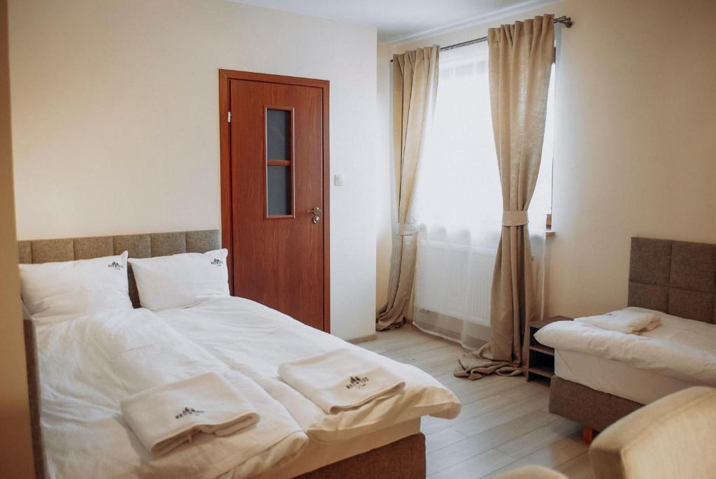 a bedroom with a large bed and a window at Redwood Hostel in Lublin