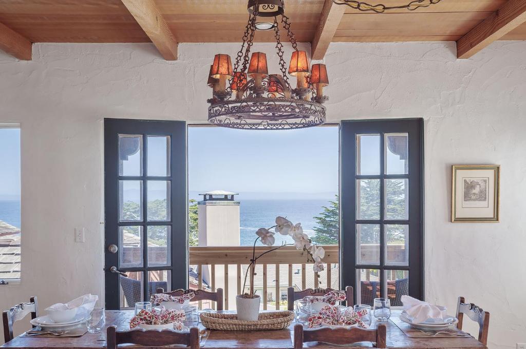 comedor con mesa y lámpara de araña en 3263 Villa by the Sea townhouse en Pacific Grove