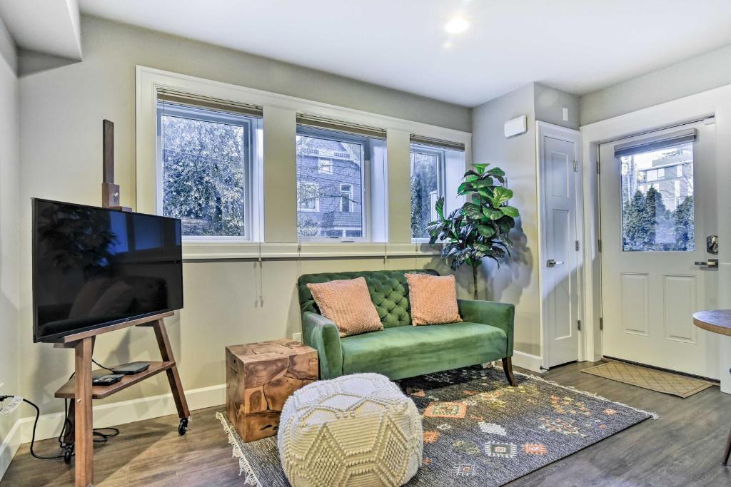 a living room with a green couch and a flat screen tv at Walkable Portland Studio Less Than 1 Mi to Dtwn! in Portland