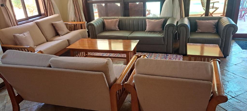 een woonkamer met banken en stoelen en een tafel bij Three bedroom luxury home in Ukunda