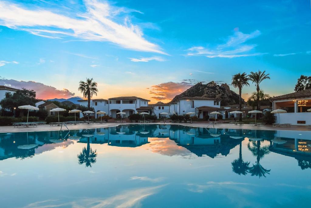 聖瑪麗亞納瓦雷的住宿－Marina Torre Navarrese Resort，日落时欣赏度假村的游泳池景致