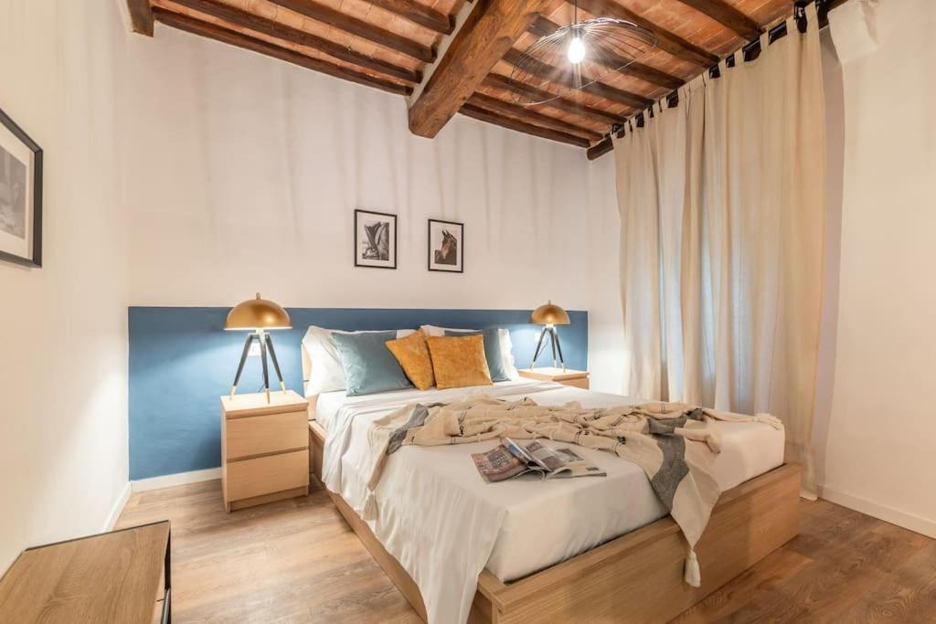 1 dormitorio con 1 cama grande y suelo de madera en Horse Apartment nel centro di Siena, en Siena