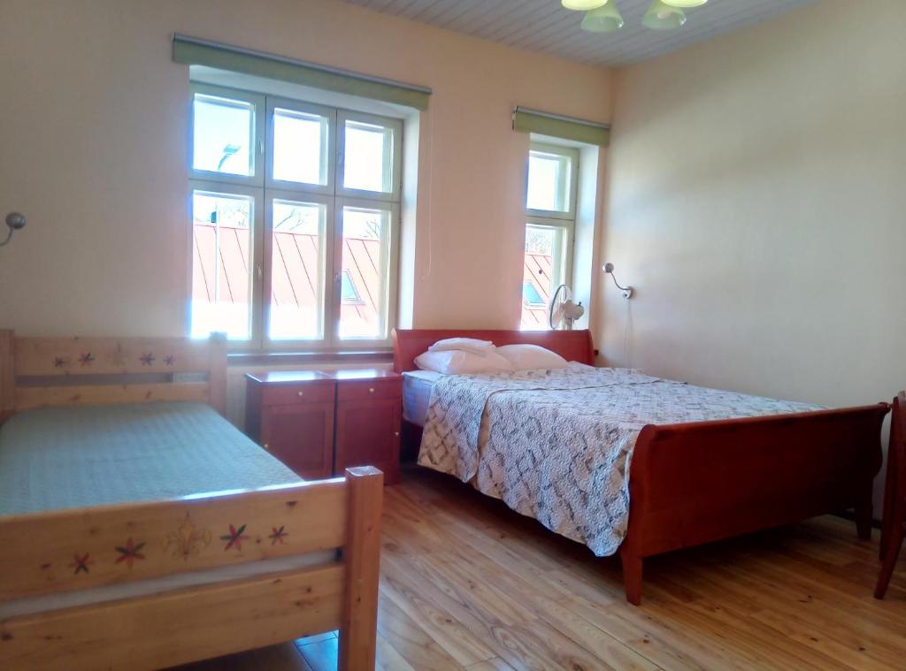 een slaapkamer met 2 bedden en 2 ramen bij TäheMaja3 in Viljandi