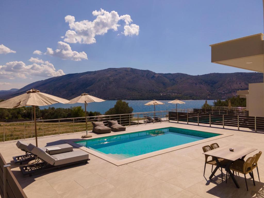 - une piscine avec vue sur l'eau et les montagnes dans l'établissement Plataria Sunrise Resort, à Plataria