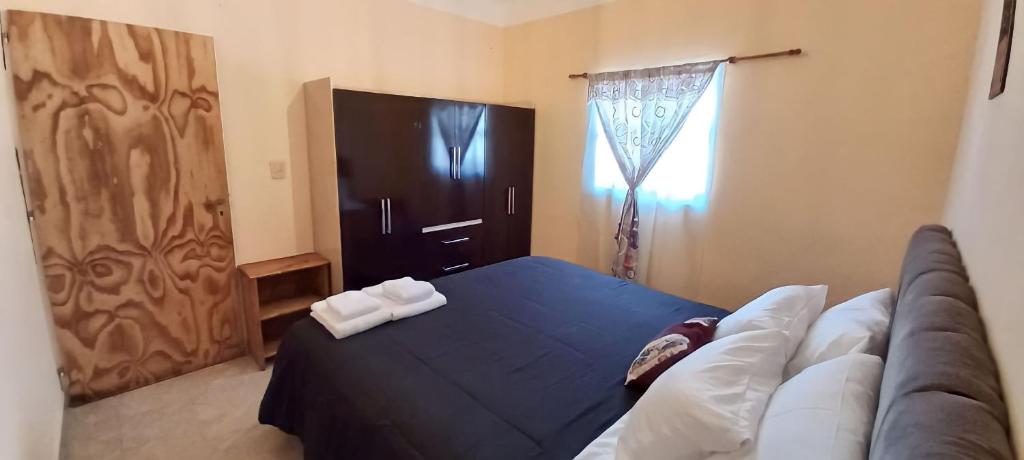 1 dormitorio con 1 cama azul y 1 sofá en Departamentos Tilcara en Tilcara
