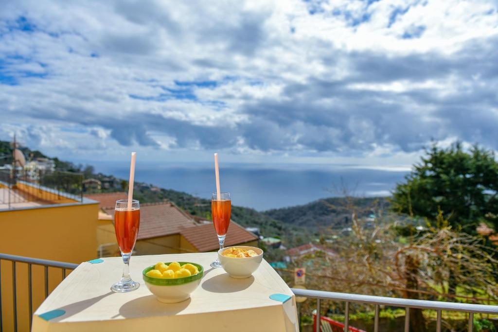 a table with two drinks and a bowl of fruit on a balcony at Moon Smile in Massa Lubrense