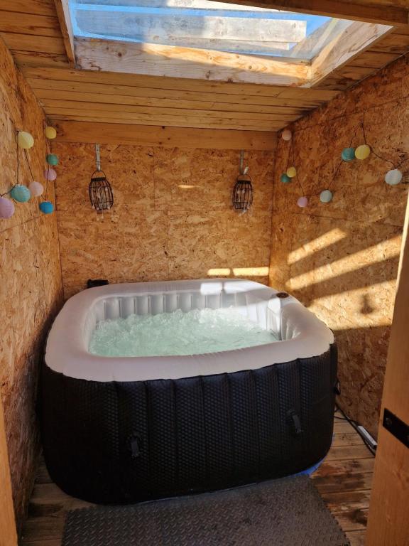 a large bath tub in a building with a roof at Le Garage in Cussy