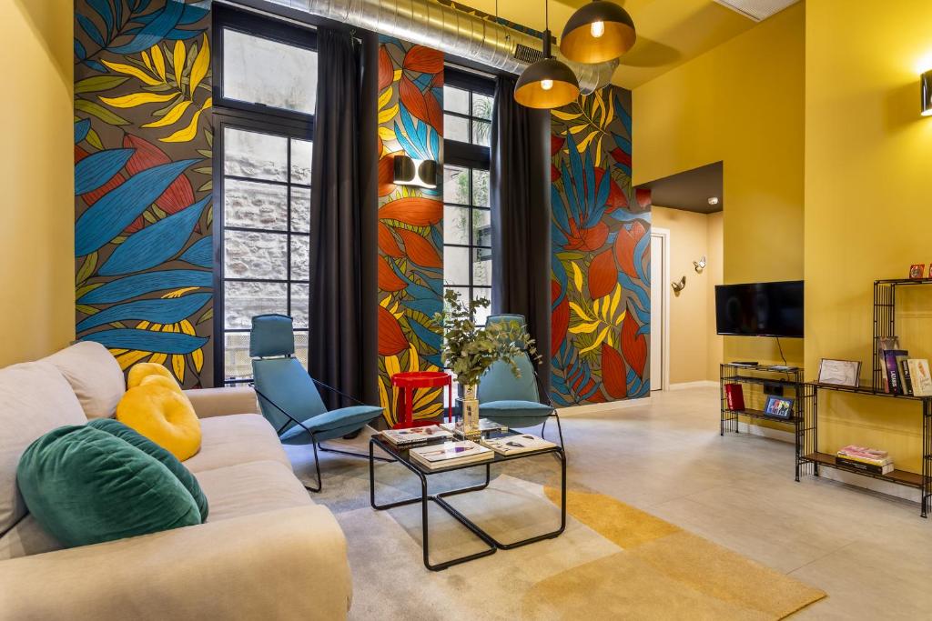 a living room with a couch and a colorful wall at Amazinn Places EVIapartments in Valencia