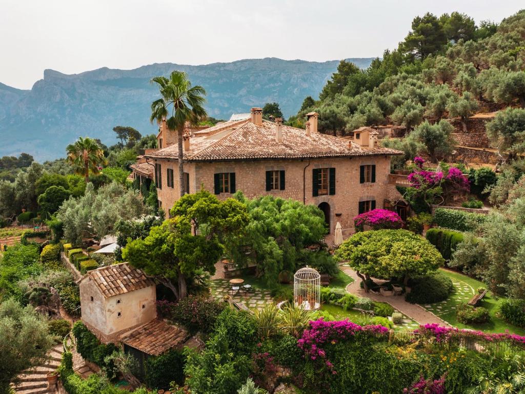 an old house in a garden with flowers and trees at Ca's Xorc Luxury Retreat - ADULTS ONLY in Sóller