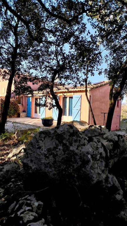 un grand rocher devant un bâtiment arboré dans l'établissement La Rose Des Vents & Spa - Gite Provence, à Néoules
