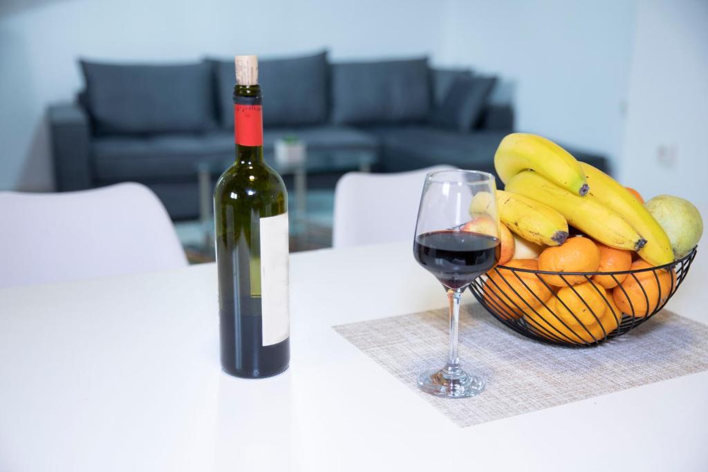 eine Flasche Wein neben einem Obstkorb in der Unterkunft Zorbas House in Iraklio