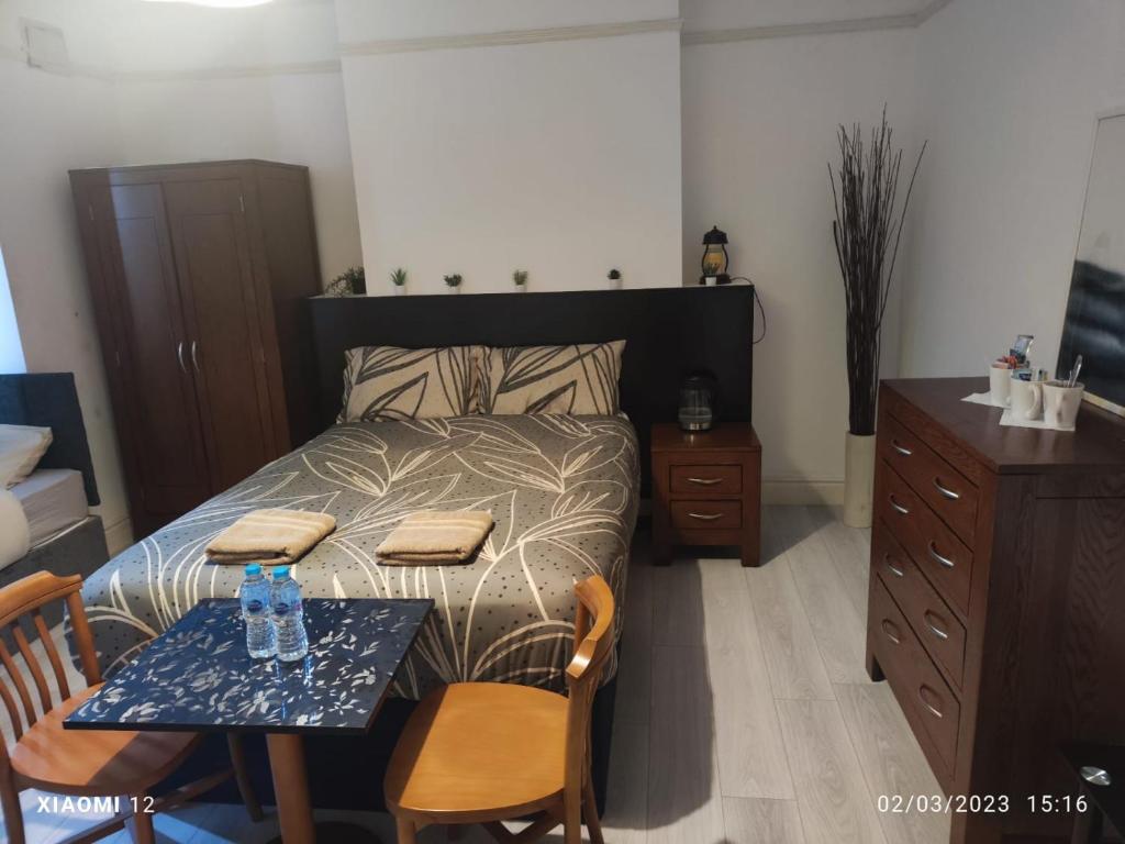 sypialnia z łóżkiem ze stołem i krzesłami w obiekcie St Lucia lodge Leicester long stays available w mieście Leicester