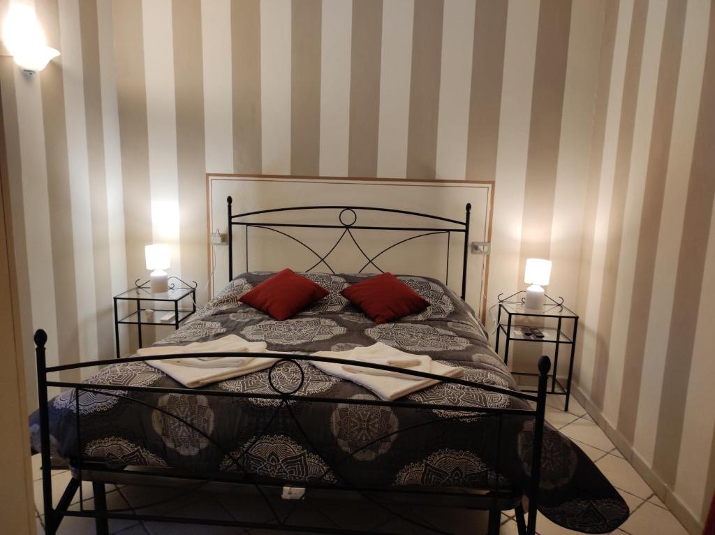 a bed with two red pillows in a bedroom at La piccola Posta di Cortona in Cortona