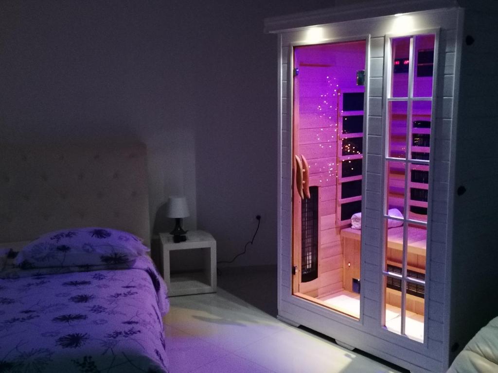 a bedroom with a bed and a window with purple lights at VILA MOLET KOPER in Koper