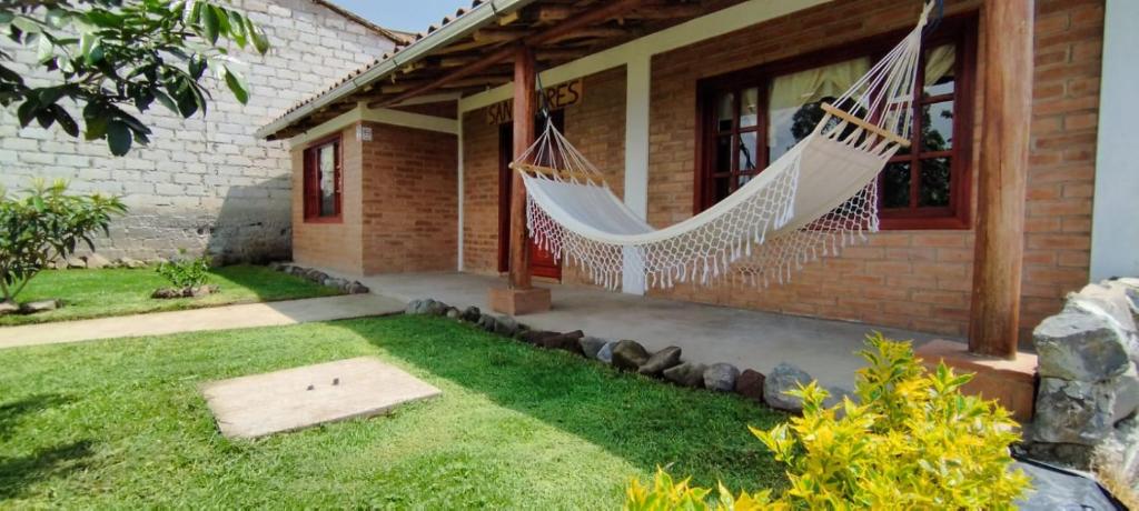 una casa con una hamaca fuera de ella en Cabaña San Andres en Otavalo