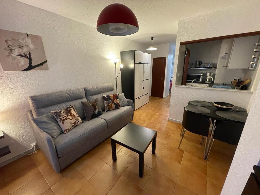 sala de estar con sofá, mesa y cocina en Immodelpas Madriu, en Pas de la Casa