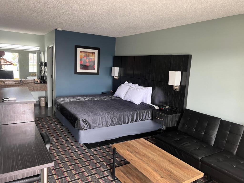 Habitación de hotel con cama y sofá en Executive Inn, en Pelham