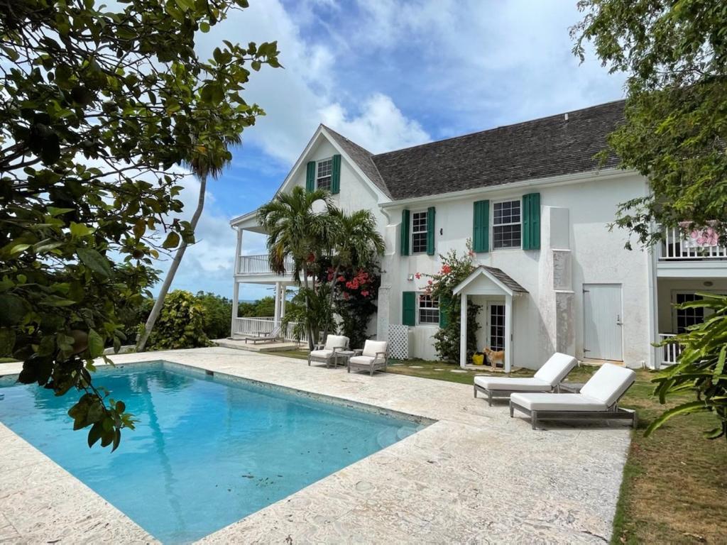 une maison avec une piscine et une maison dans l'établissement Buccaneer Hill Main House home, à Governorʼs Harbour