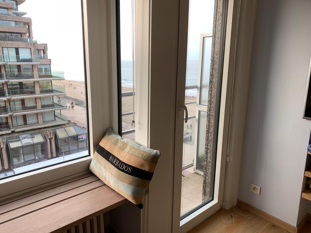 a window with a bench with a view of the beach at Sunny studio with seaview in Knokke-Heist