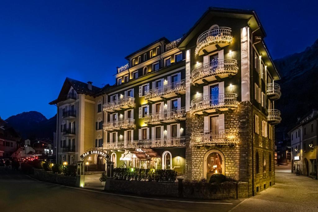 ボルミオにあるHotel San Lorenzoの夜間はバルコニー付きの建物