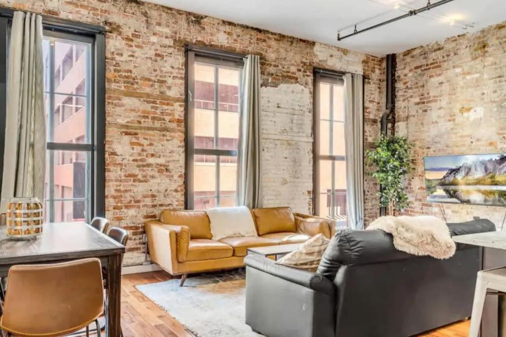 una sala de estar industrial con una pared de ladrillo en 30 S 7th St Unit 3 LUXURIOUS Million Dollar Condo Elevator Parking Location, en Filadelfia