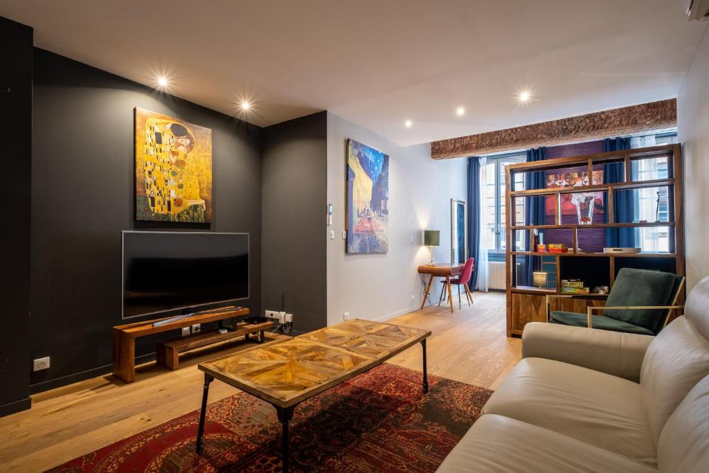 Televízia a/alebo spoločenská miestnosť v ubytovaní Appartement de prestige – rue des Arts
