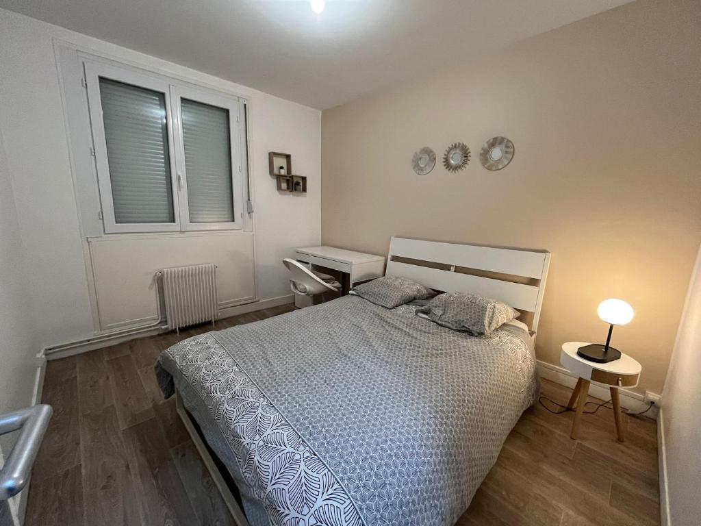 a bedroom with a bed and a desk and a window at Appartement Prestige - Amiens in Amiens