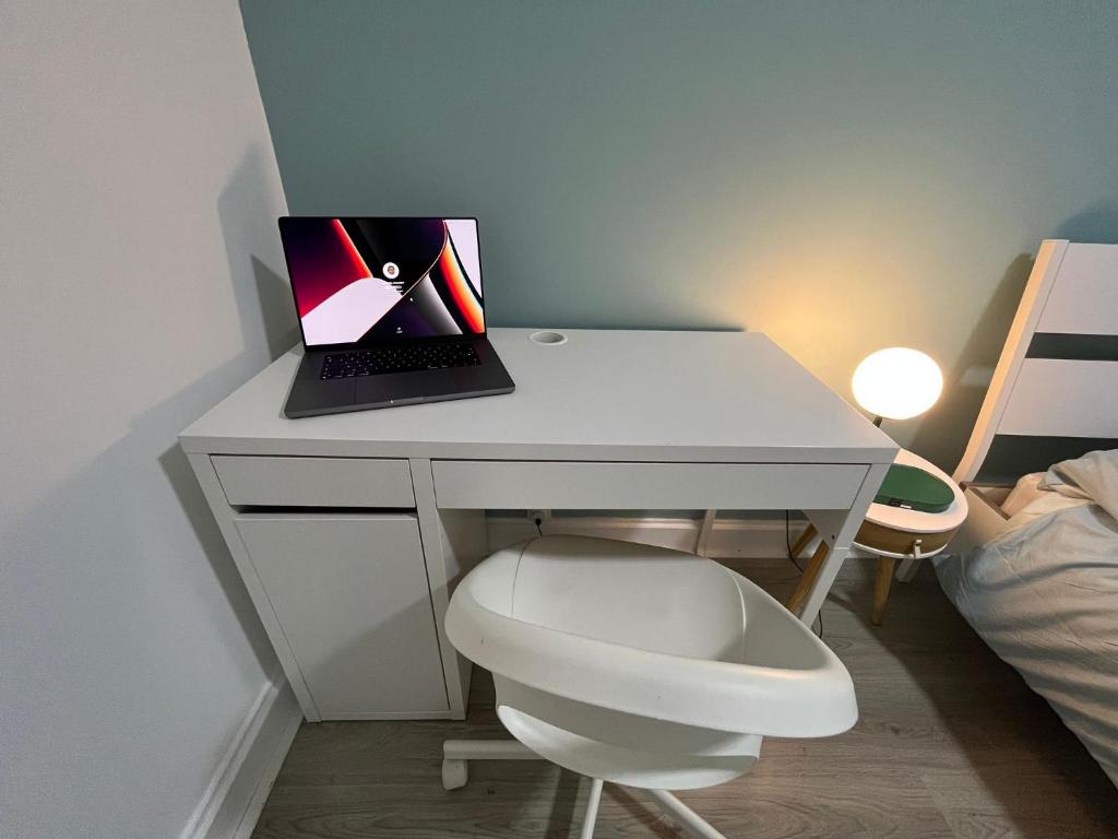 a white desk with a laptop and a white chair at Appartement Prestige - Amiens in Amiens