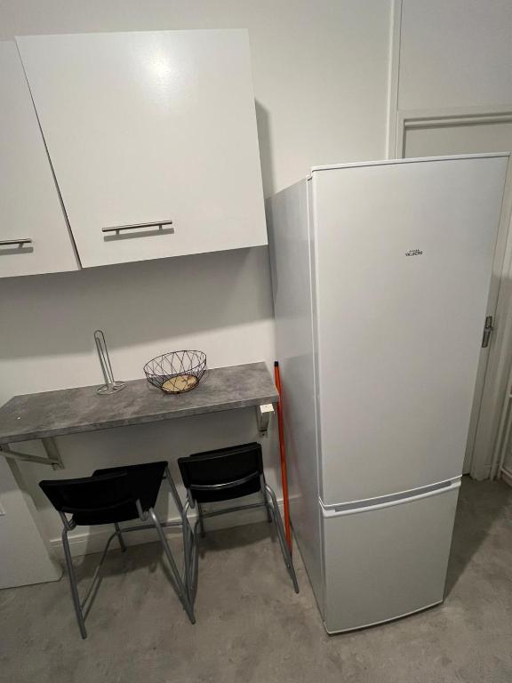 a kitchen with a table and a refrigerator at Appartement Prestige - Amiens in Amiens