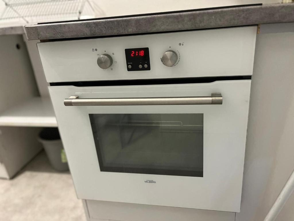 a white oven with a clock on it in a kitchen at Appartement Prestige - Amiens in Amiens