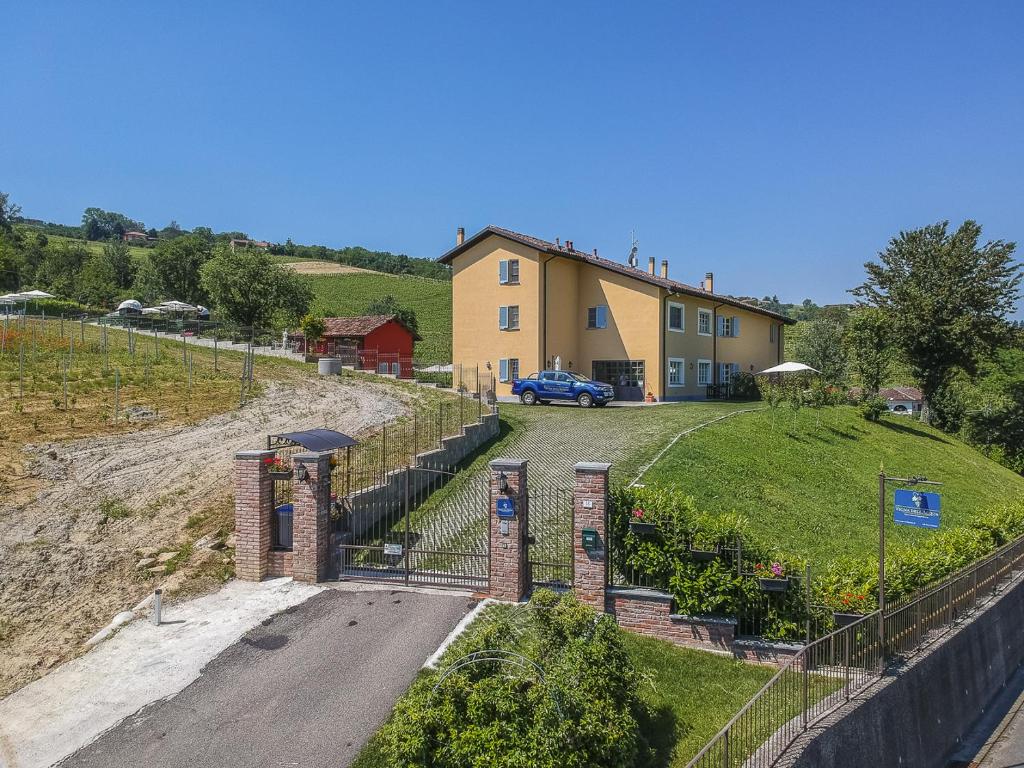 a house on a hill with a fence and a driveway at Vigna Dell'Acqua in Santo Stefano Belbo