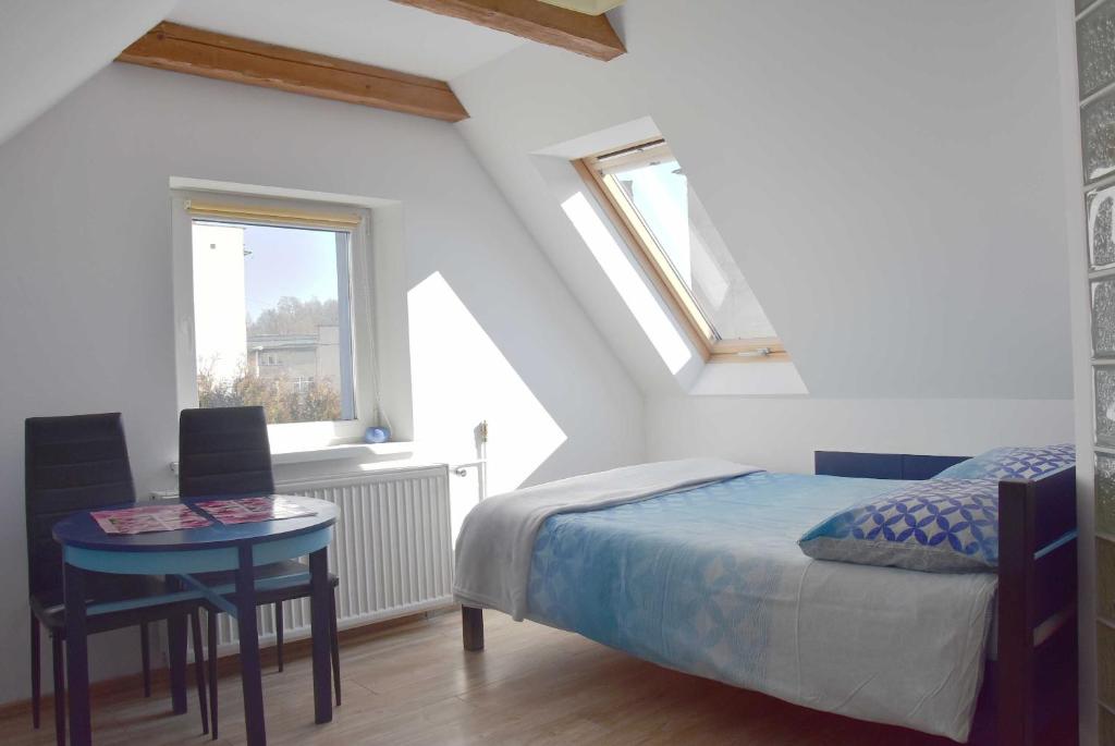 um quarto com uma cama, uma mesa e uma janela em Ziołowy Zakątek em Jedlina-Zdrój