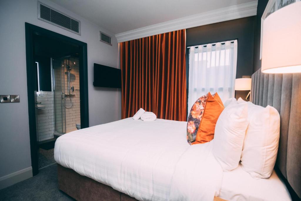 um quarto com uma grande cama branca com almofadas laranja em Thomas Moore Inn em Dublin