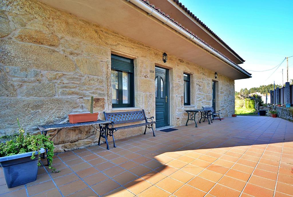 a patio with benches on the side of a building at Casa Rural Manuela in As Mirans