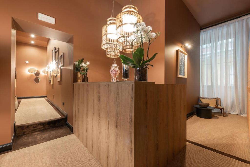 a hallway with a large chandelier and a wooden wall at The Couper Castello in Milan