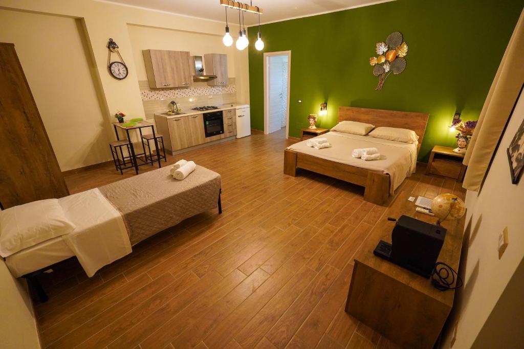 ein großes Wohnzimmer mit 2 Betten und einer Küche in der Unterkunft Il Geranio b&b in Acconia