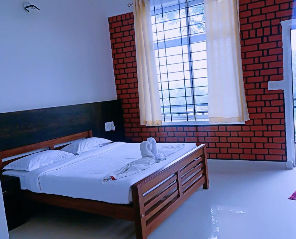 um quarto com uma cama e uma grande janela em SERENITY GREENS em Madikeri