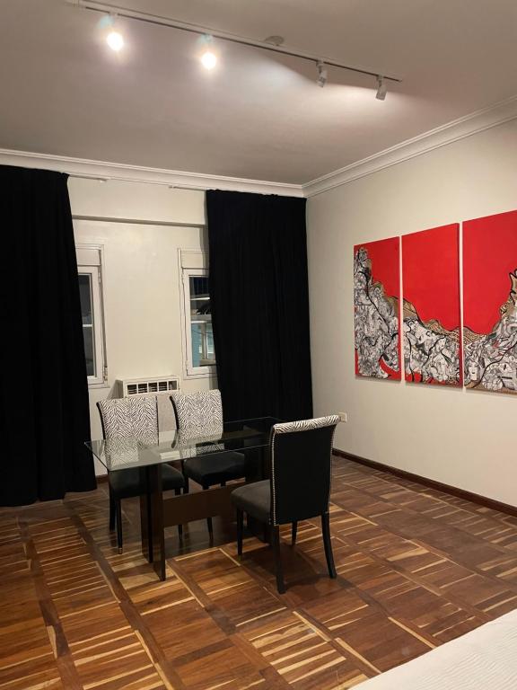 a dining room with a table and chairs and a painting at Victoria Plaza in Santiago del Estero