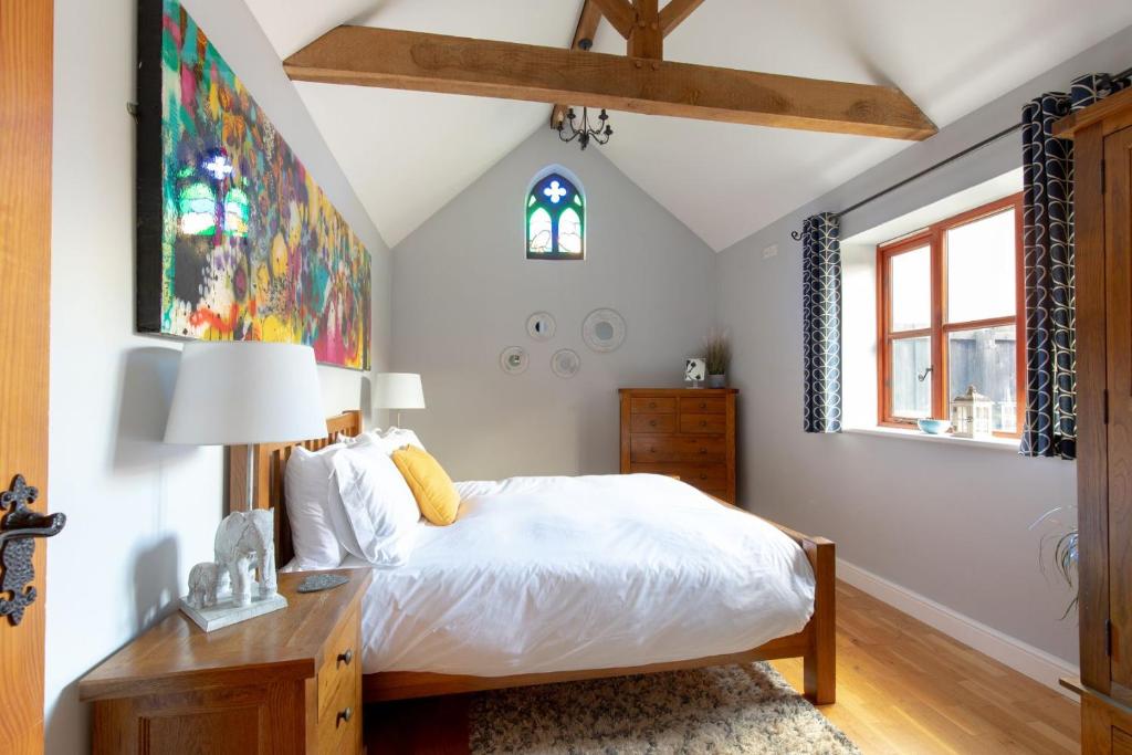 a bedroom with a white bed and a window at Woodbury Cottage in Woodbury