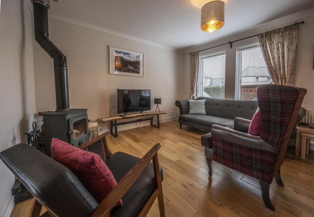 ein Wohnzimmer mit Couch und Ofen in der Unterkunft Sugarloaf in Fort William
