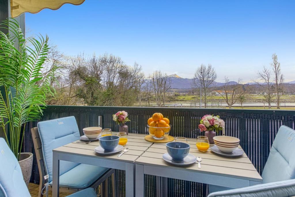 - une table avec un bol de fruits sur le balcon dans l'établissement Charming flat with view on the Pyrénées - Saint-Jean-de-Luz - Welkeys, à Saint-Jean-de-Luz