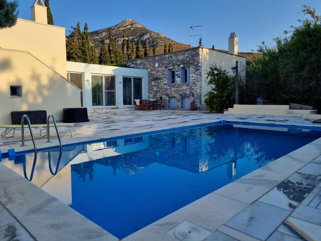 a villa with a swimming pool in front of a house at Margouno Eco-Villa, Eggares, Naxos in Eggares