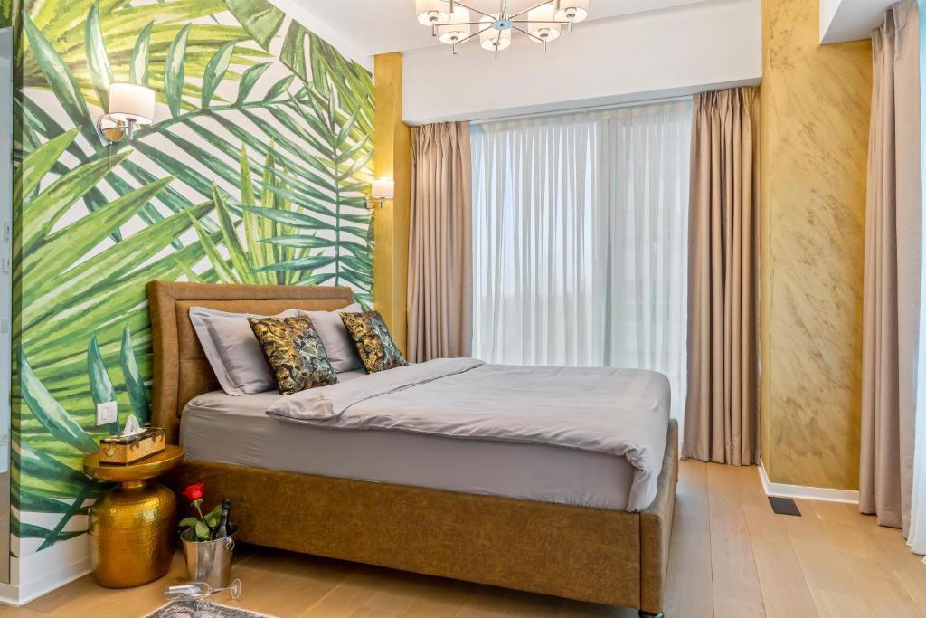 1 dormitorio con 1 cama con un mural tropical en ONE Tower Apartments, en Bucarest