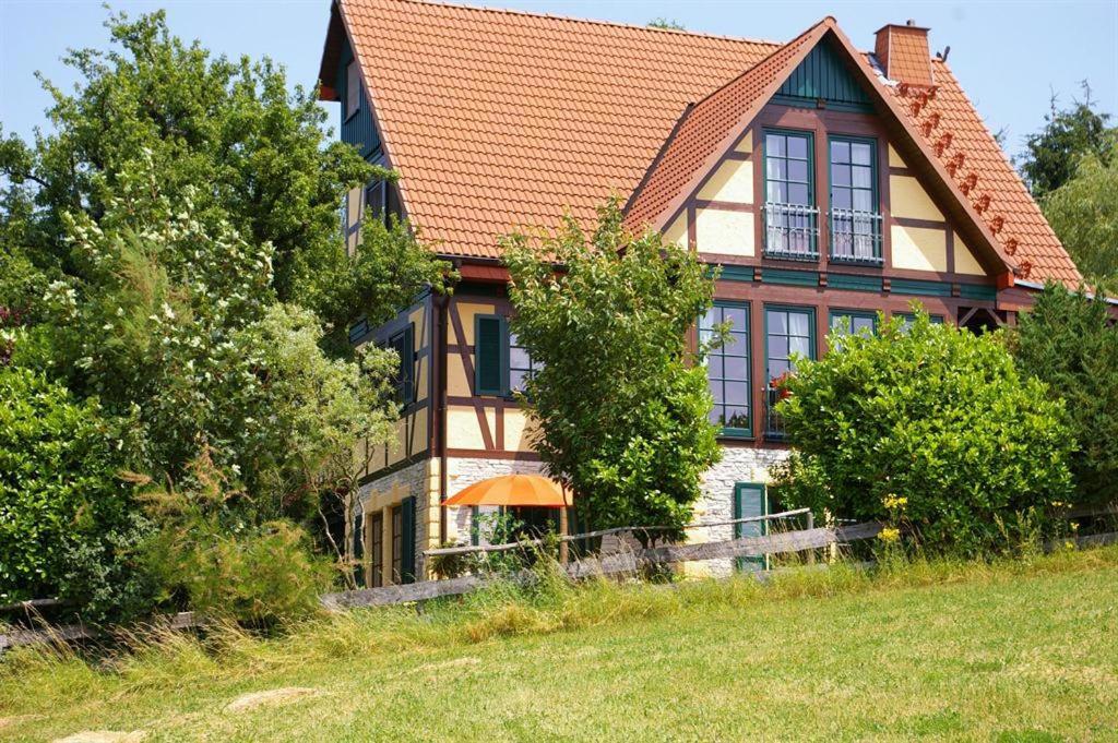 uma casa numa colina com árvores em frente em Kölliger Hirtenhaus 