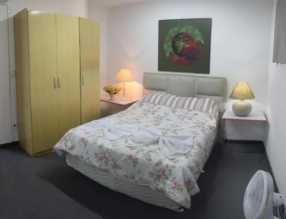 1 dormitorio con 1 cama y 2 mesitas de noche en Suíte de hóspedes independente com cozinha, en Teresópolis