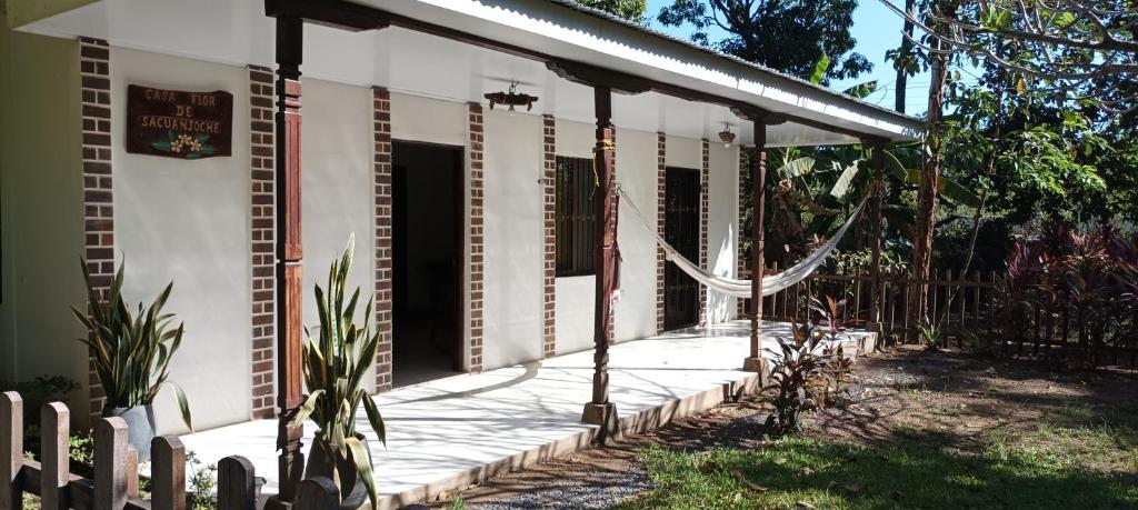 Biały dom z gankiem i ogrodzeniem w obiekcie Flor de Sacuanjoche, Chinandega w mieście Chinandega