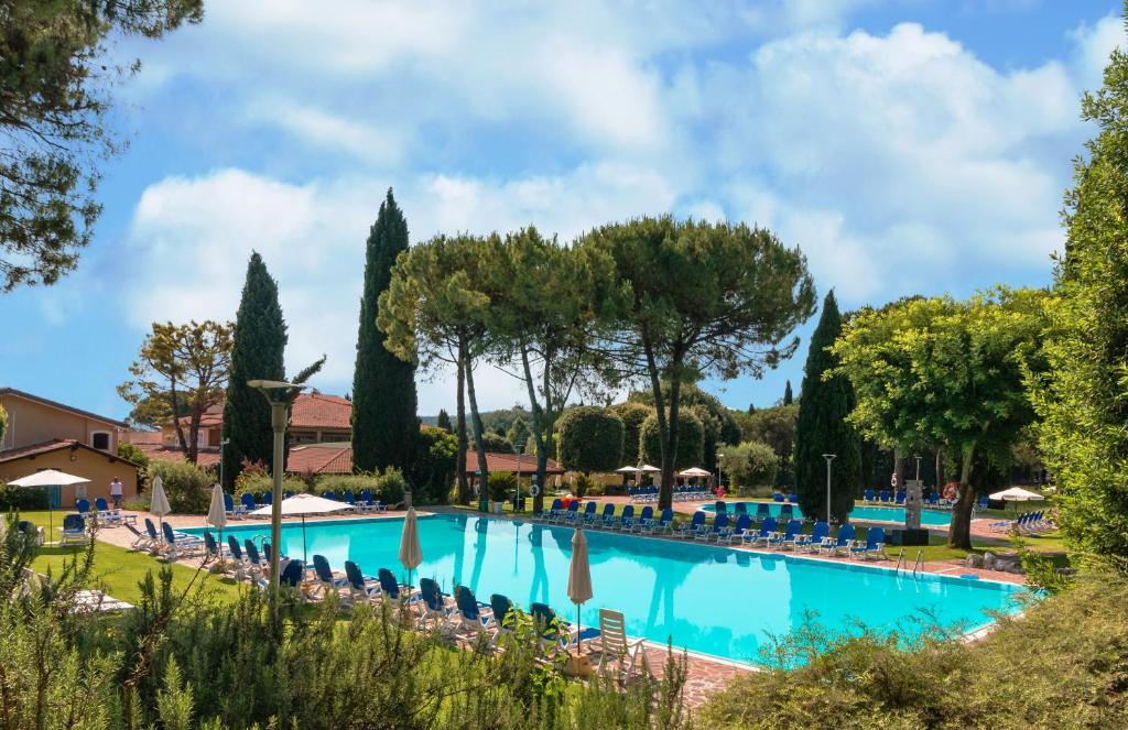 a swimming pool in a resort with chairs and trees at West Garda Hotel in Padenghe sul Garda