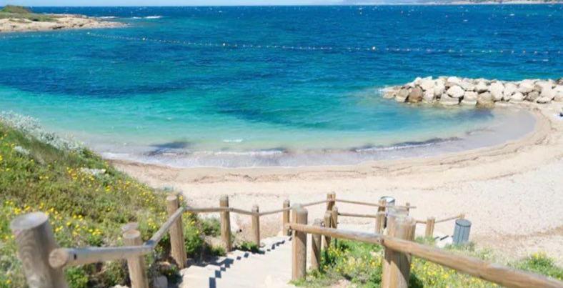 - une plage avec une clôture en bois à côté de l'océan dans l'établissement T2 Rez de jardin 4 personnes acces direct piscine superbe vue mer / Parking privé ombragé l'AM, à Six-Fours-les-Plages