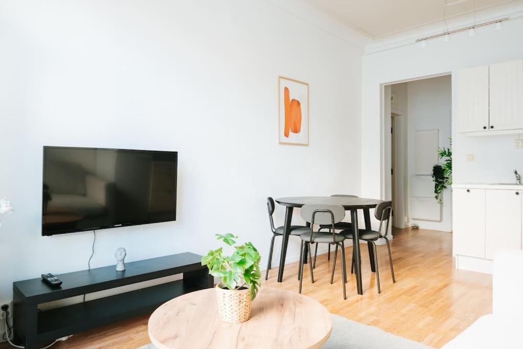 a living room with a table and a flat screen tv at City Center Apartment in Bergen